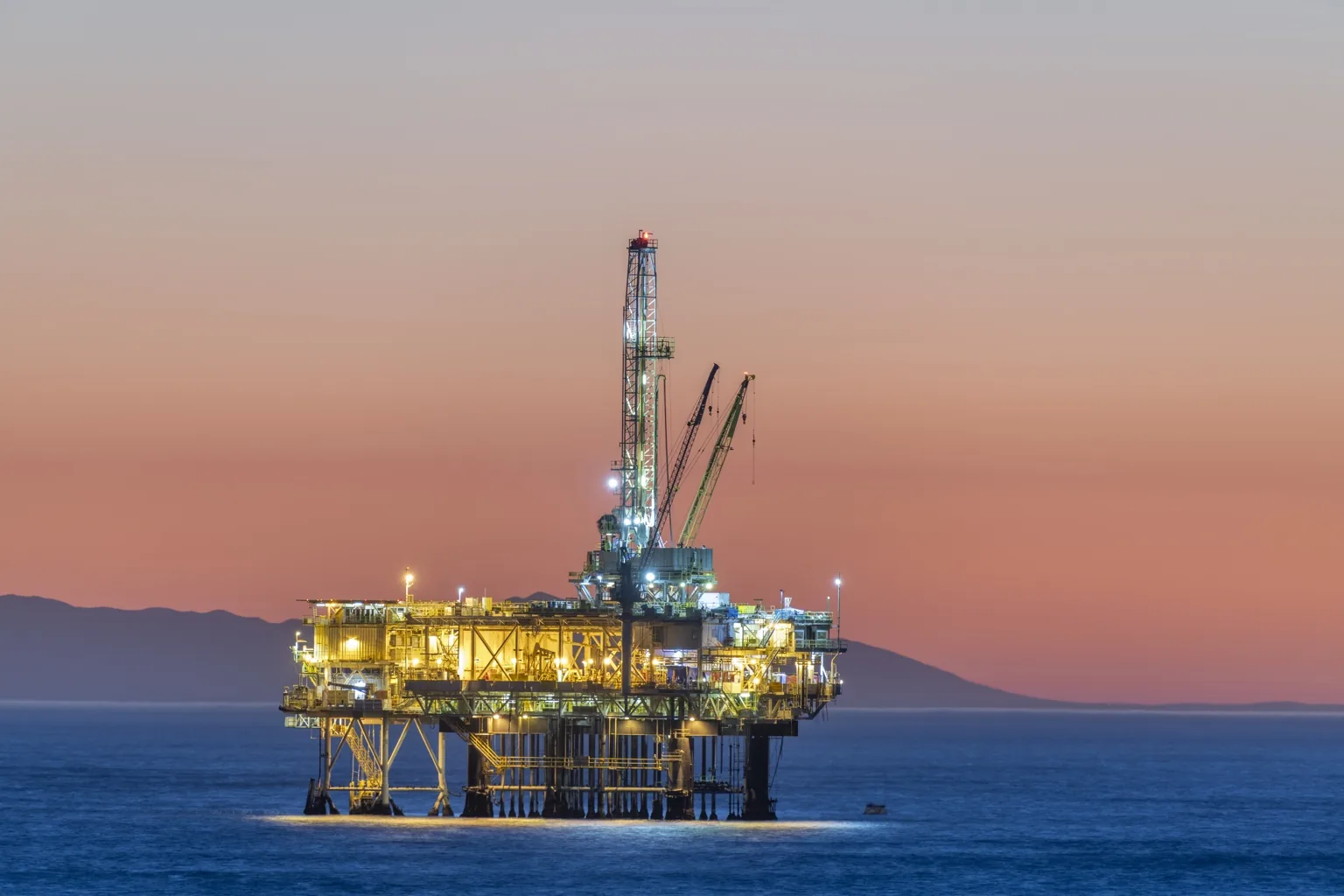 Oil and gas platform at sea during golden hour, representing the upstream oil and gas market served by this Director of Sales opportunity in Houston, TX