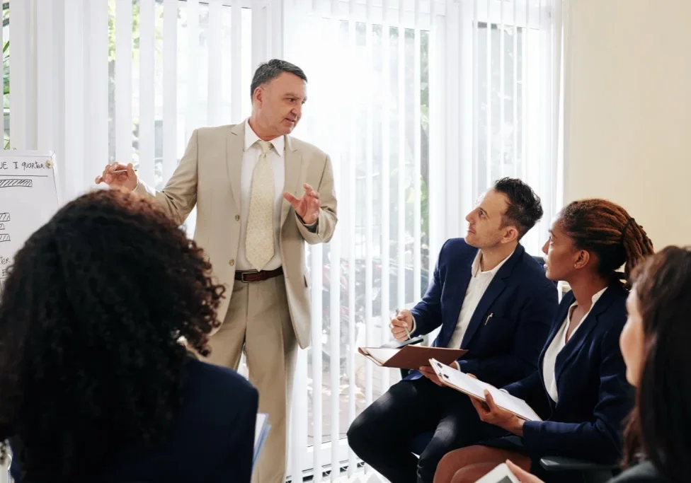 Business leader presenting a compelling job description strategy to sales team during hiring meeting