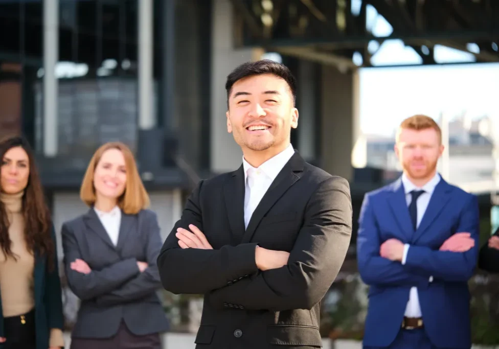 Confident sales leader standing in front of a professional team in a modern industrial setting